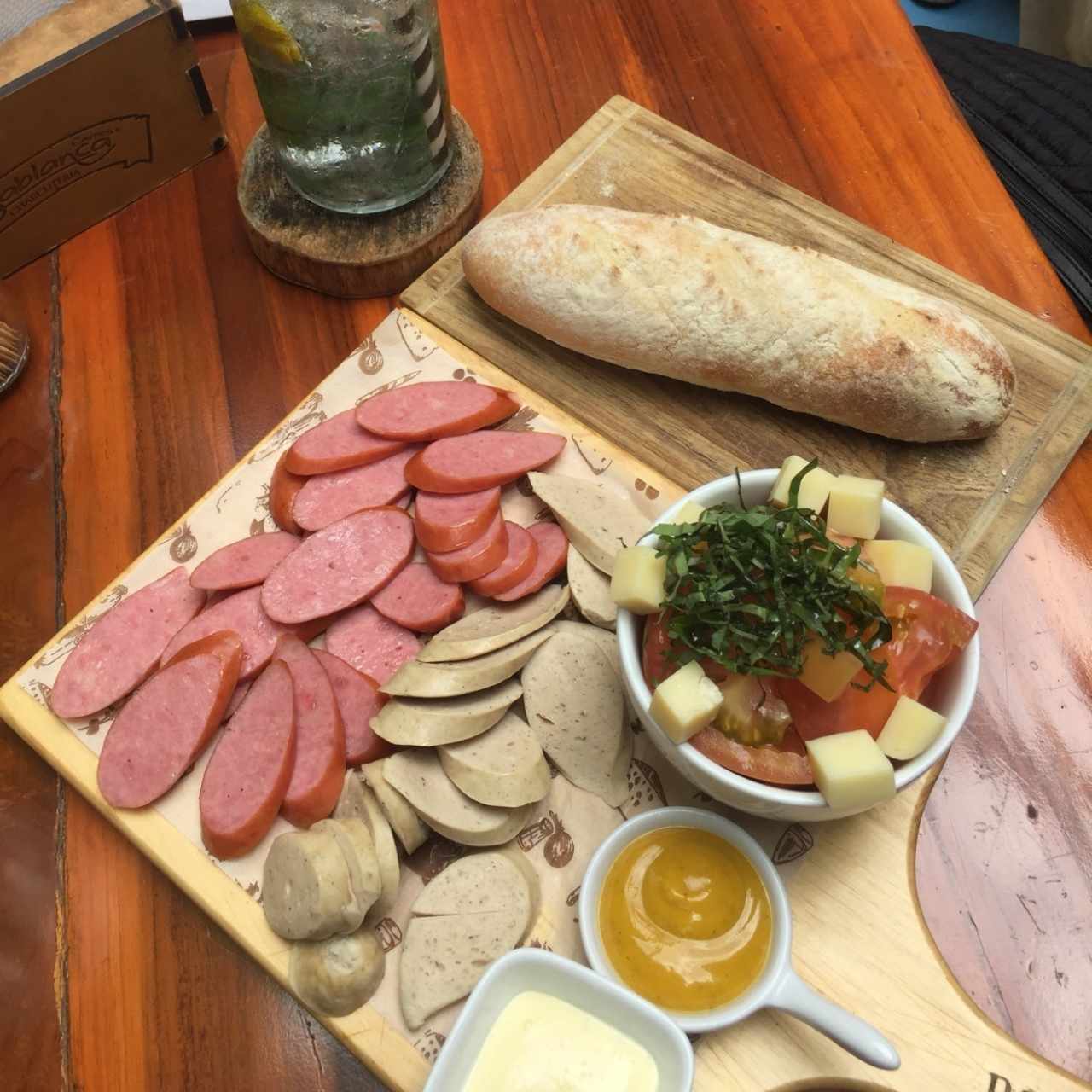 Bandeja de chorizos acompañado de un pan calientito y ensalada capresa