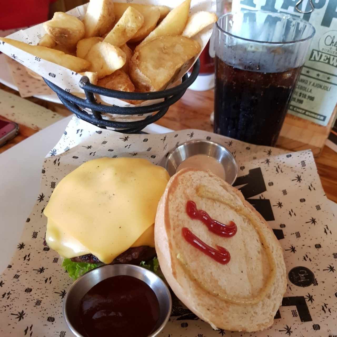Hamburguesa clásican con queso y papas rústicas.