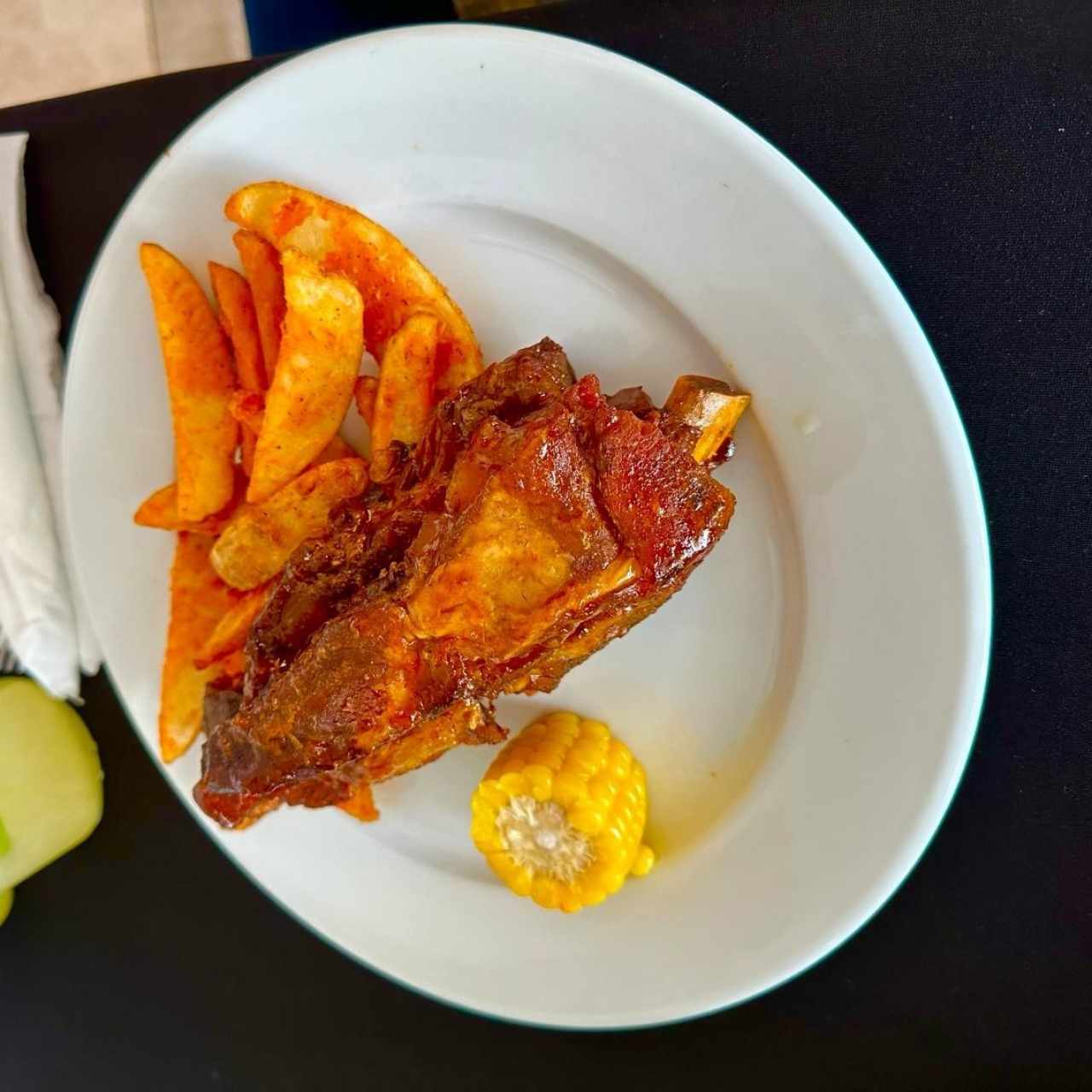 COSTILLAS CARIBEÑAS (Costillas de Puerco, en Nuestra Salsa Barbacoa con Miel de Caña y Papaya, servidas con Papas en Gajos y una Mazorca)