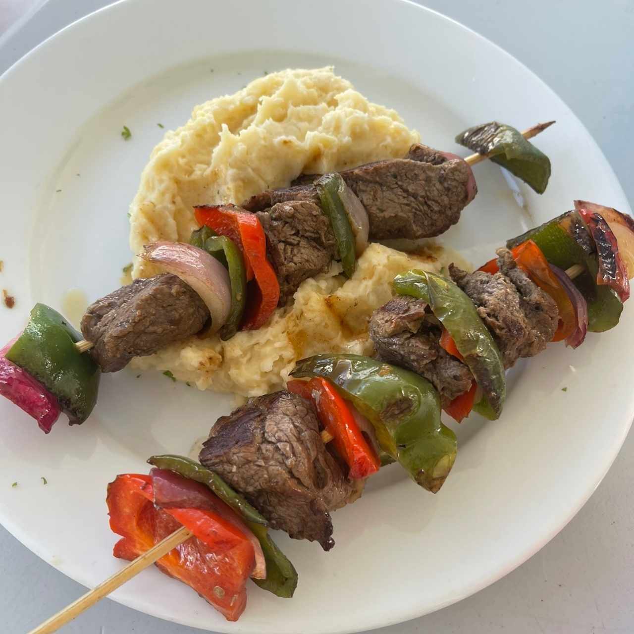 Brochetas de carne con puré de papas 