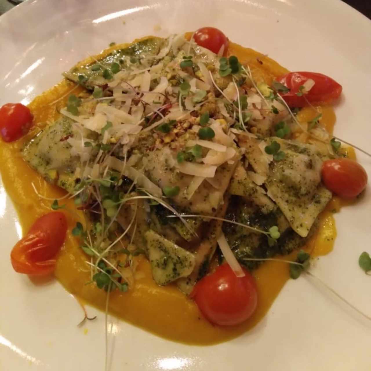Raviolini de cordero con pesto de menta, puré de calabaza y pistacho.
