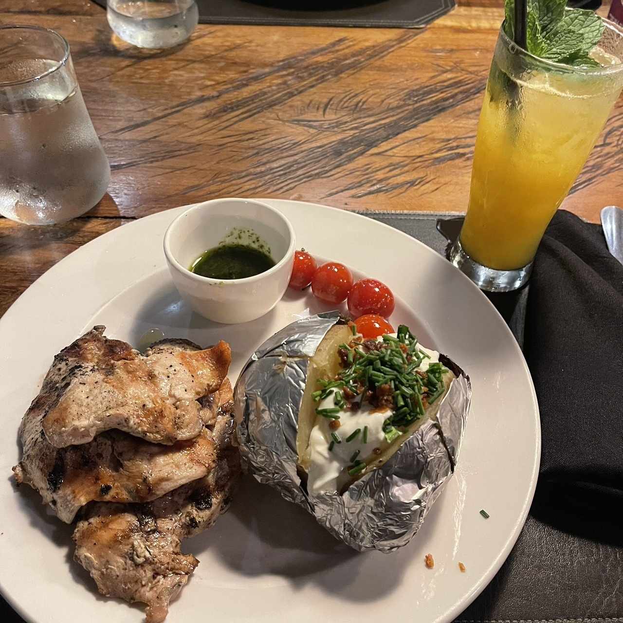 Pechuga de pollo asada ahumada, acompañamiento: papa asada rellena con tocino, cebollinas y sour cream.