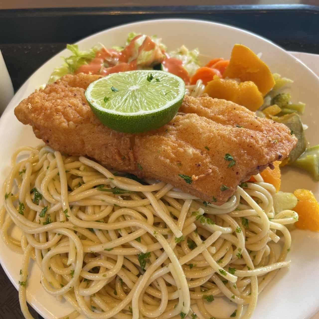 pescado con vegetales, ensalada y pasta
