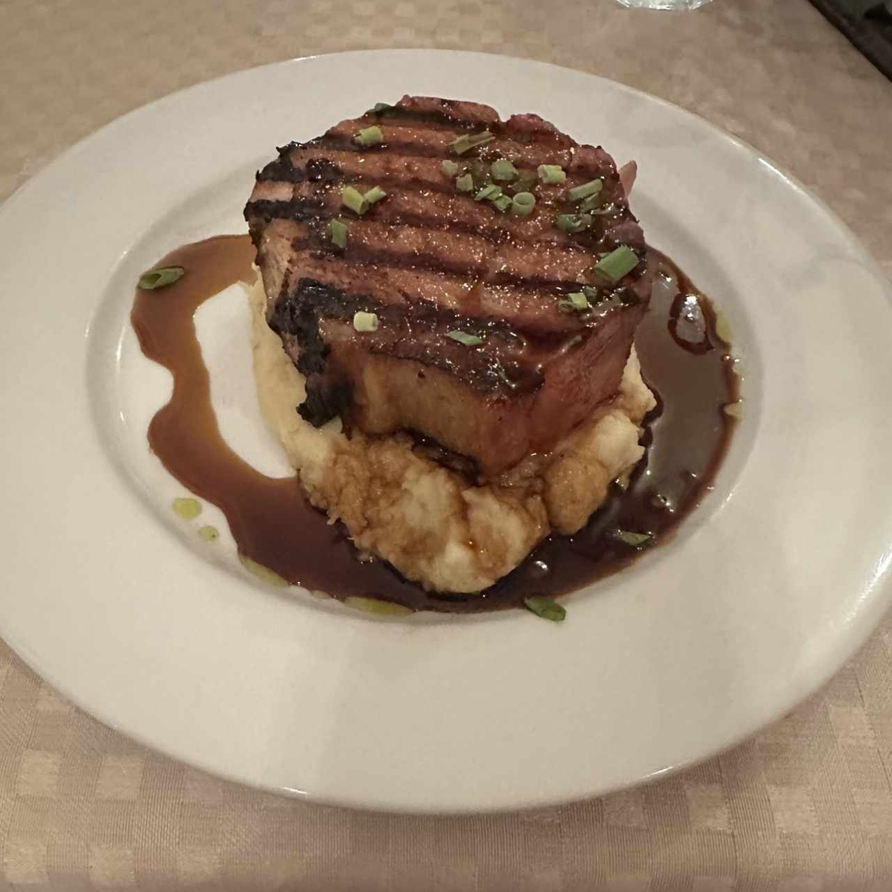 Chuleta de cerdo ahumada a la grilla con miel de caña dulce y puré de ñame