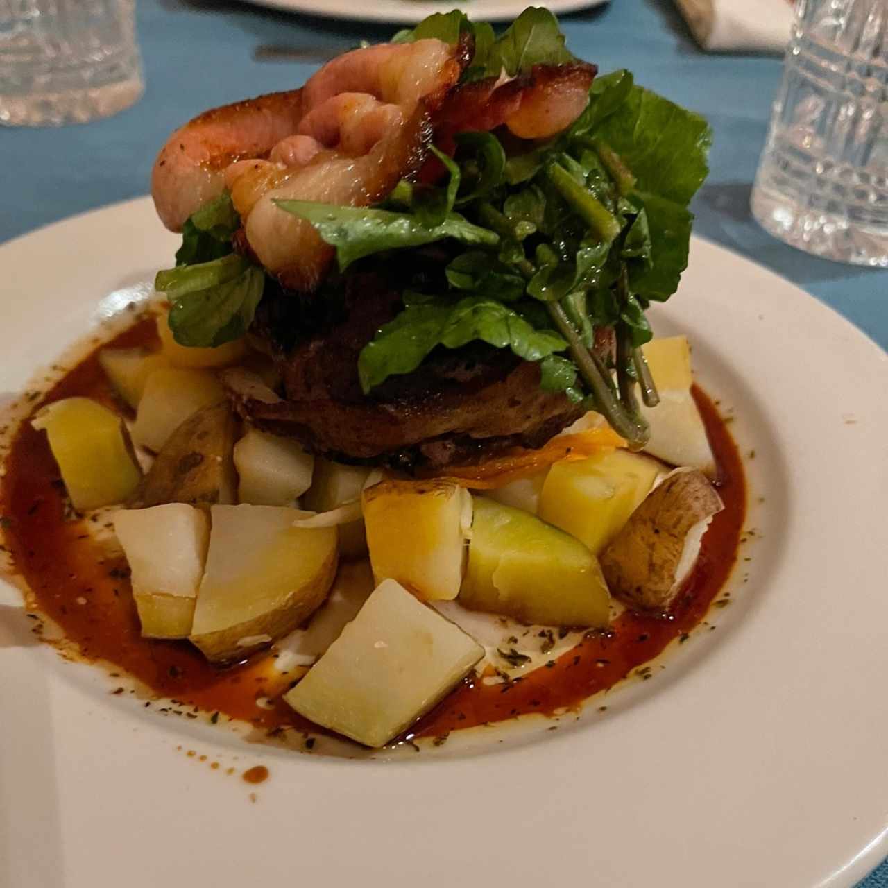 Tournedo con tocino, berro tibio, vegetales al hilo y papitas