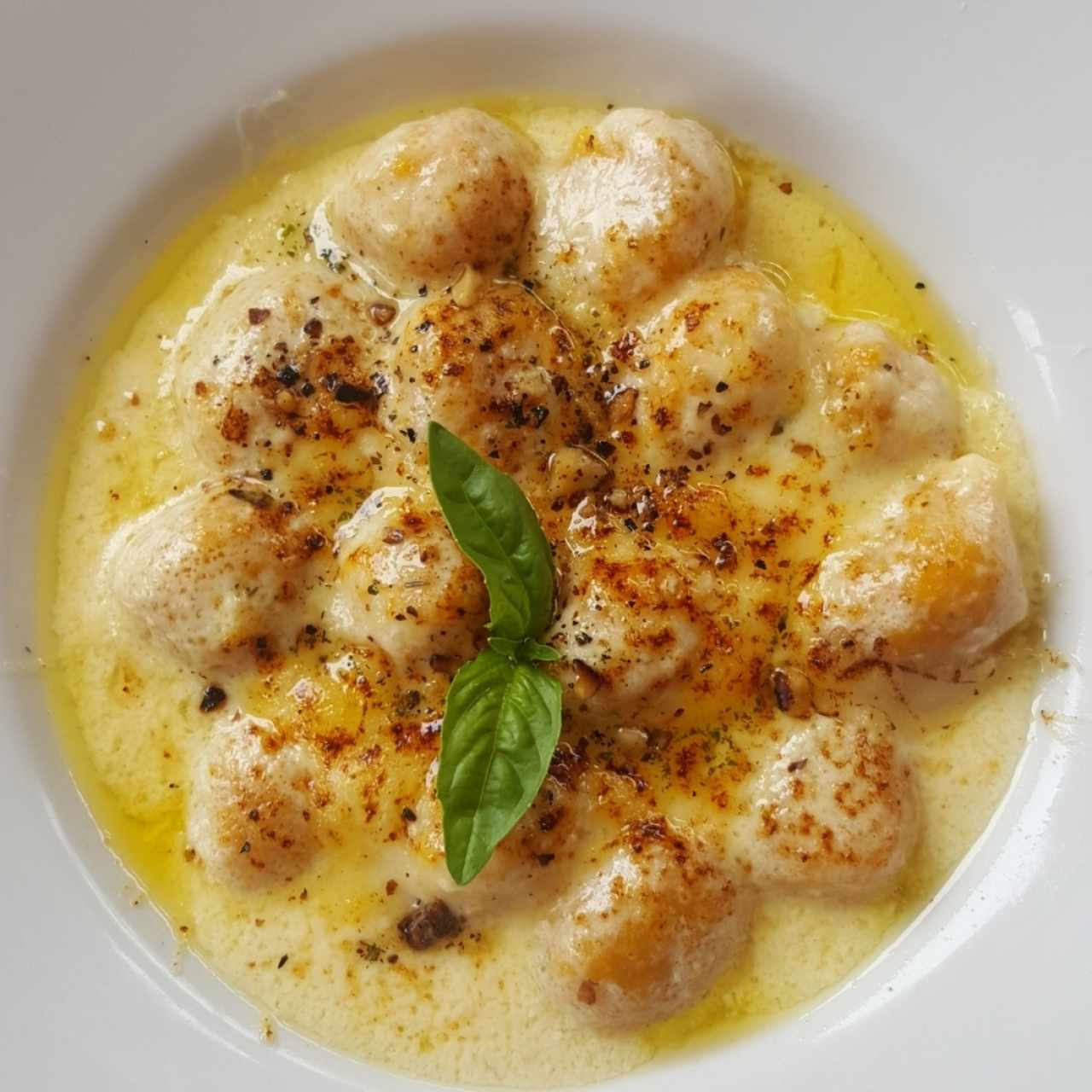 Ñoquis de zapallo en salsa de queso de cabra.
