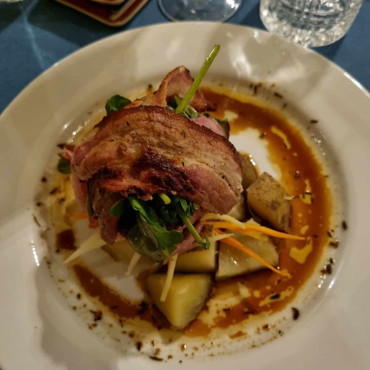 Tournedo con tocino, berro tibio, vegetales al hilo y papitas