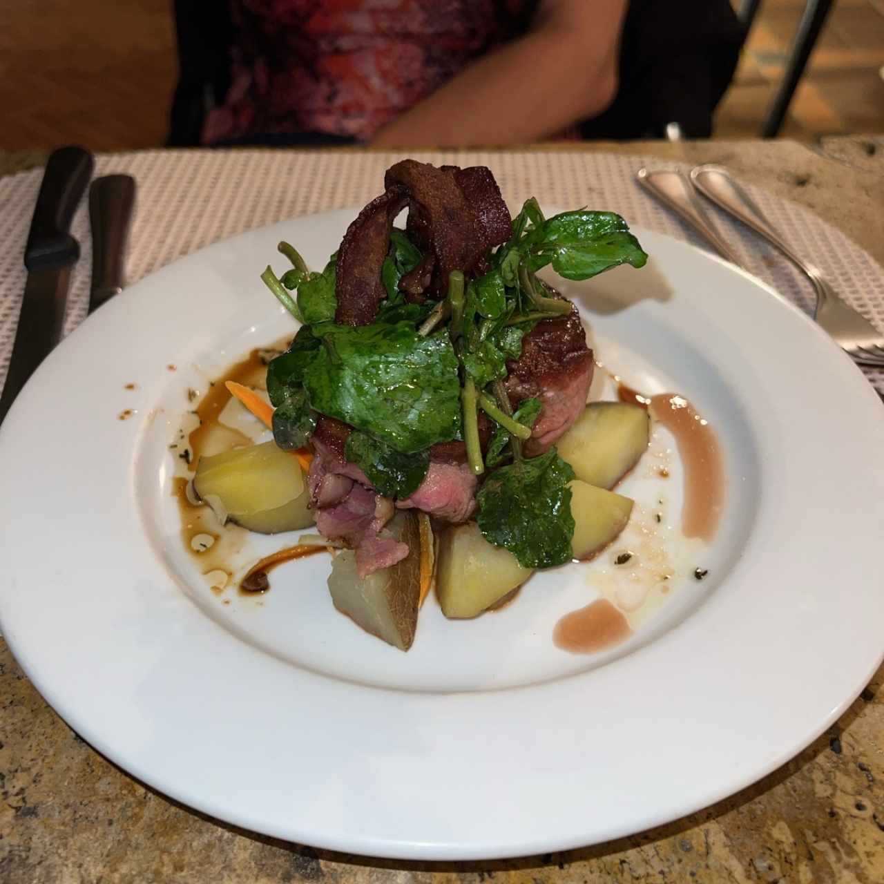 Tournedo con tocino, berro tibio, vegetales y papas hervidas