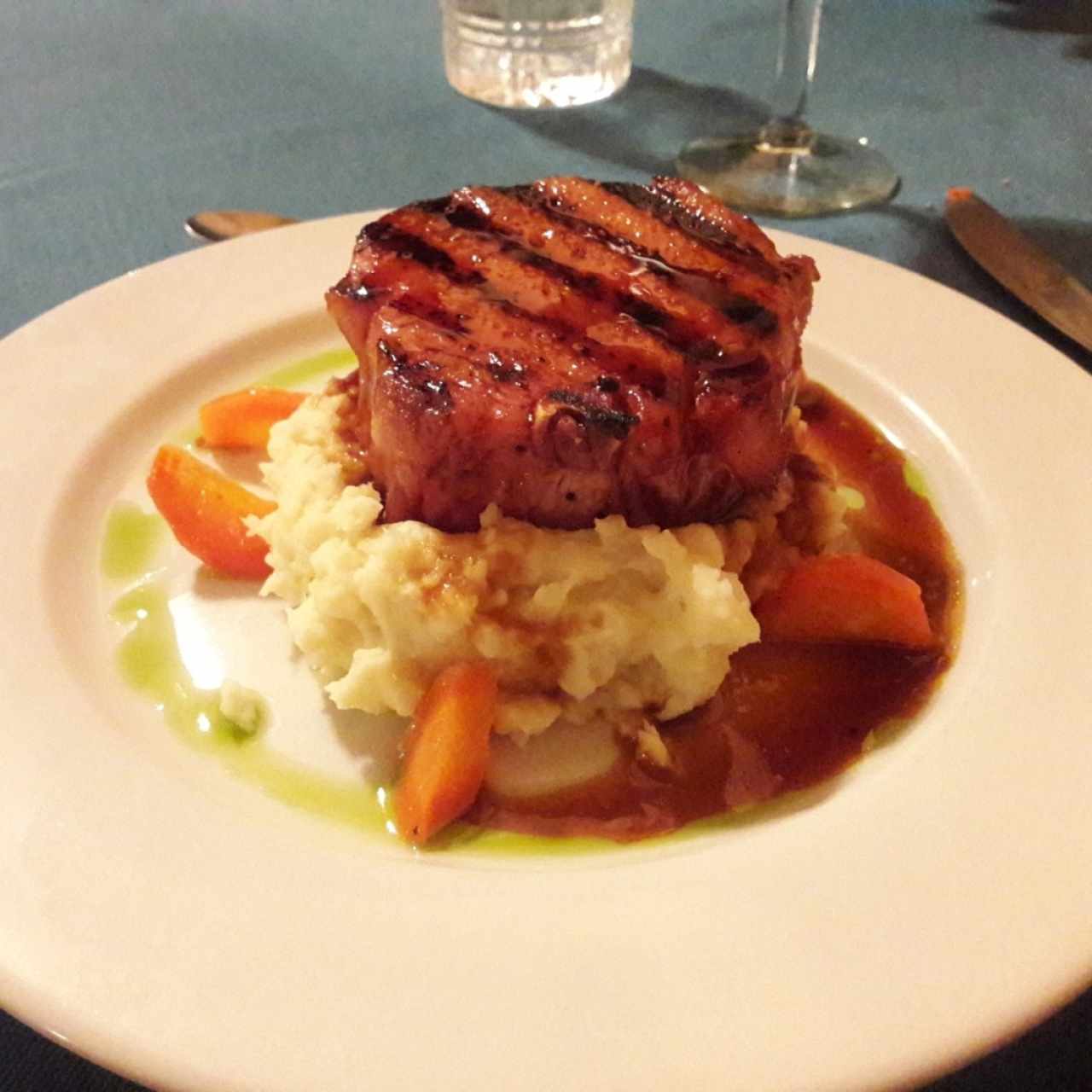 Chuleta de cerdo ahumada a la grilla con miel de caña dulce y puré de ñame