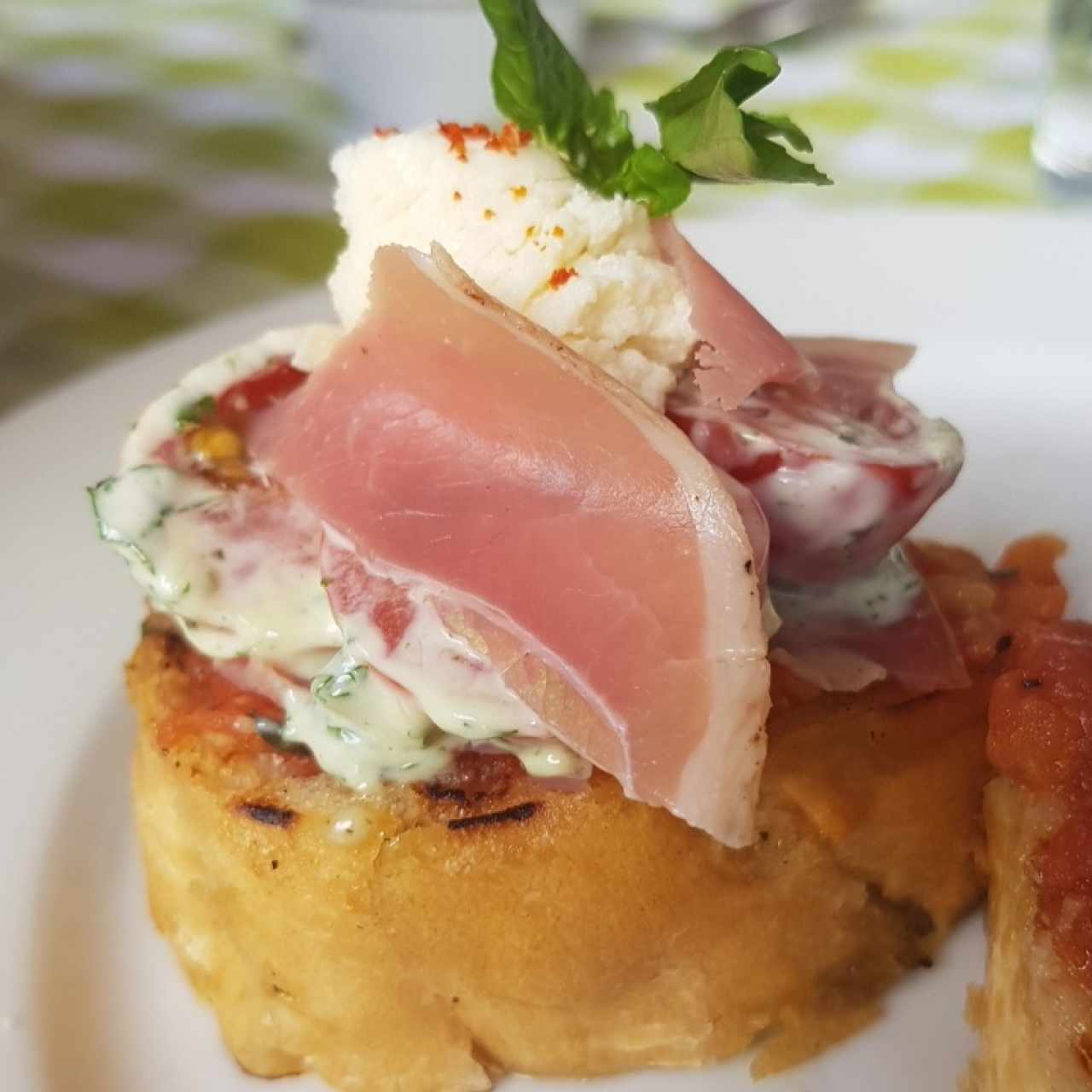 Bruschetta con tomates cherry, ricotta ahumada, brotes de berro y prosciutto (opcional)