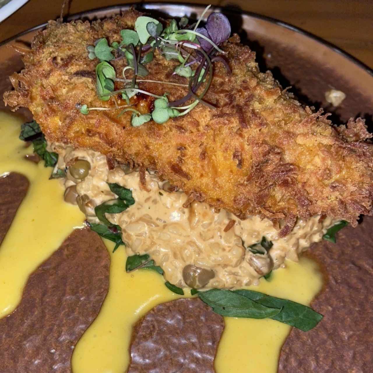 Pollo frito con coco sobre risotto de guandú