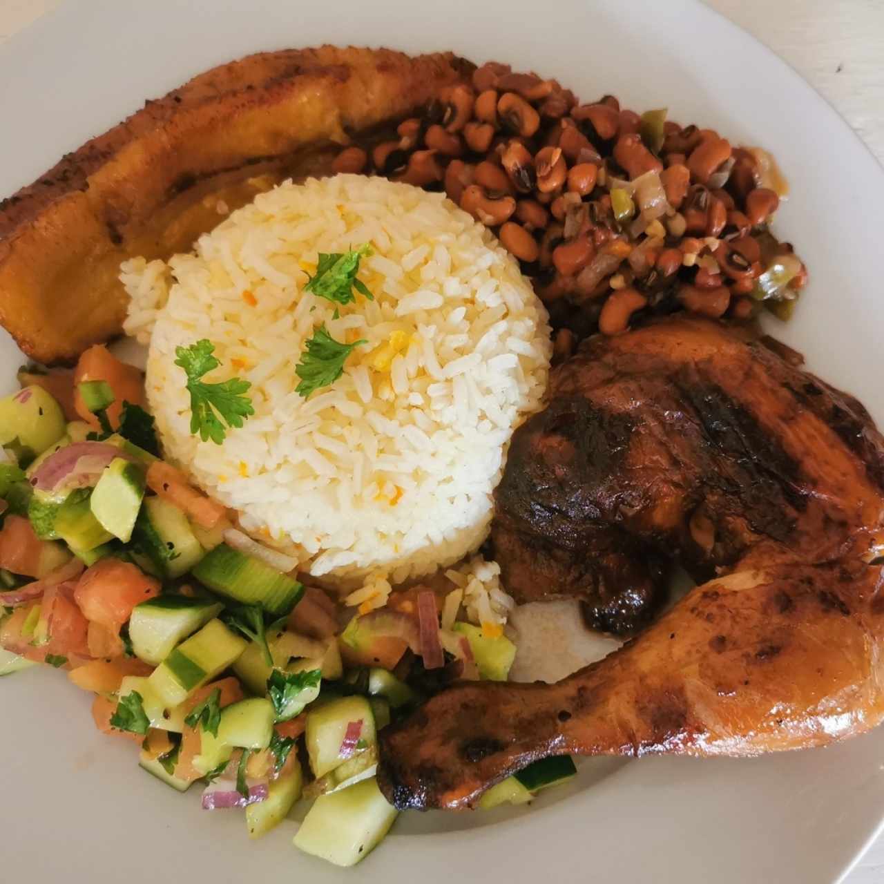 Pollo asado a la leña, ensalada, frijoles, arroz y tajada. 