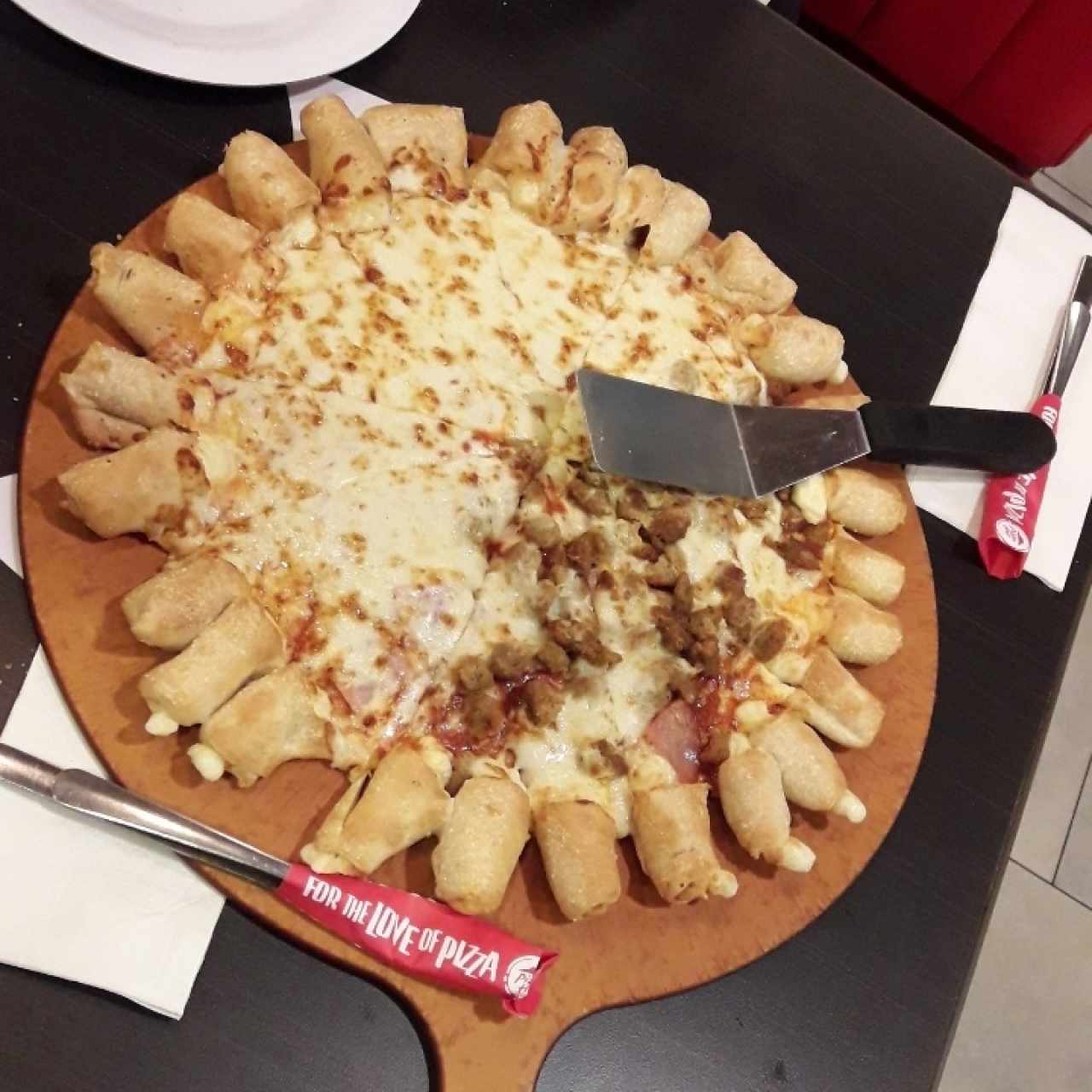 Pizza mitad de queso, mitad de carne, con bordes relleno de queso.