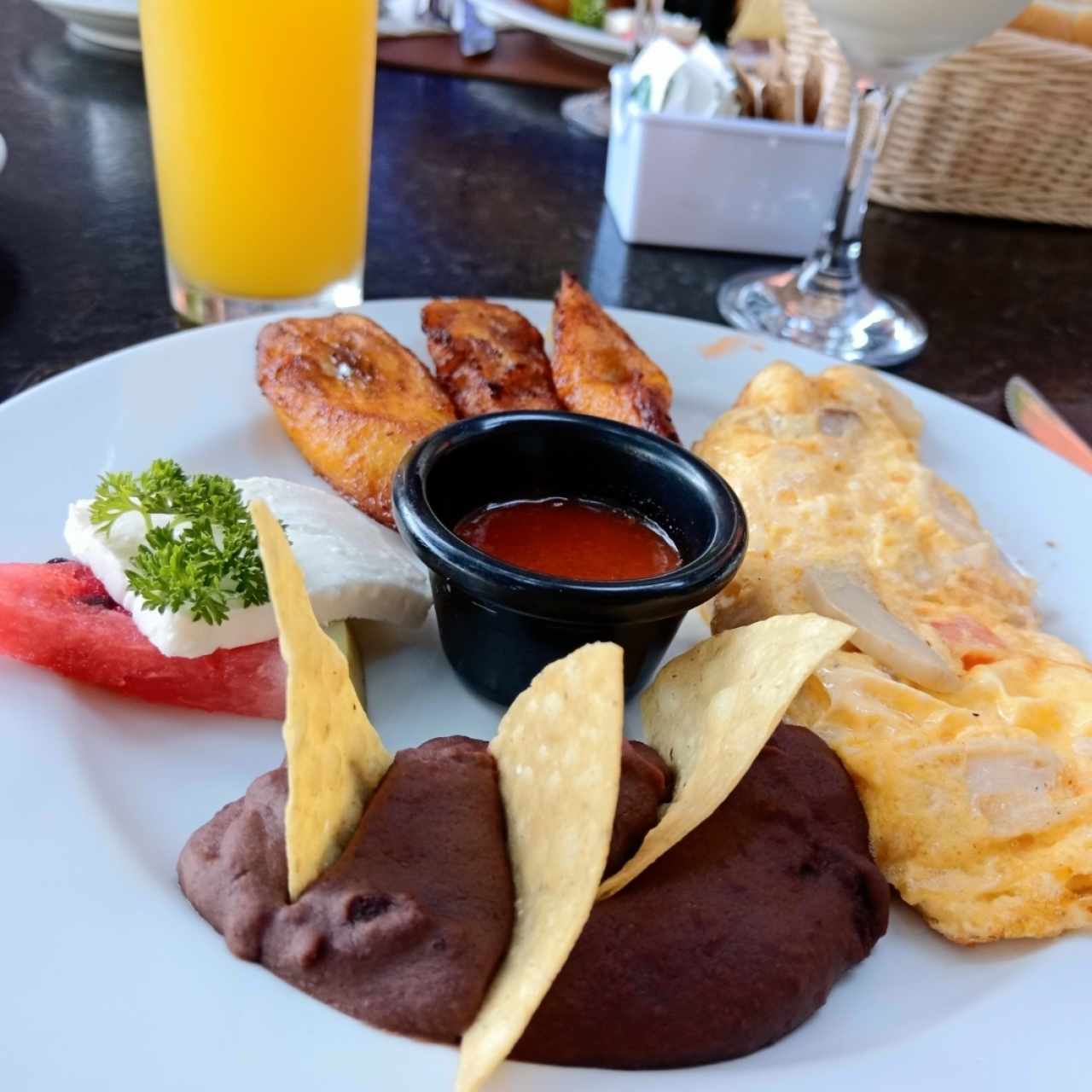 Omellete champiñones, tocino, queso acompañado de frijoles, plátanos y salsa