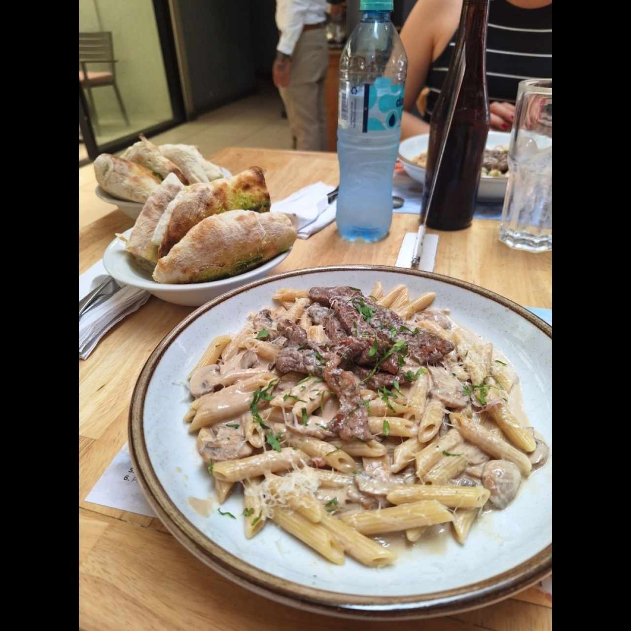 Pasta con carne y hongos. A un lado los panes.