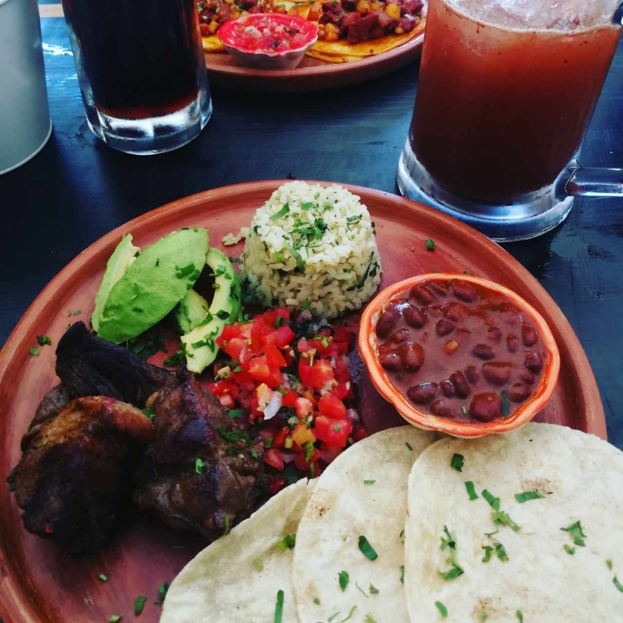 plato de carnitas y michelada de mango
