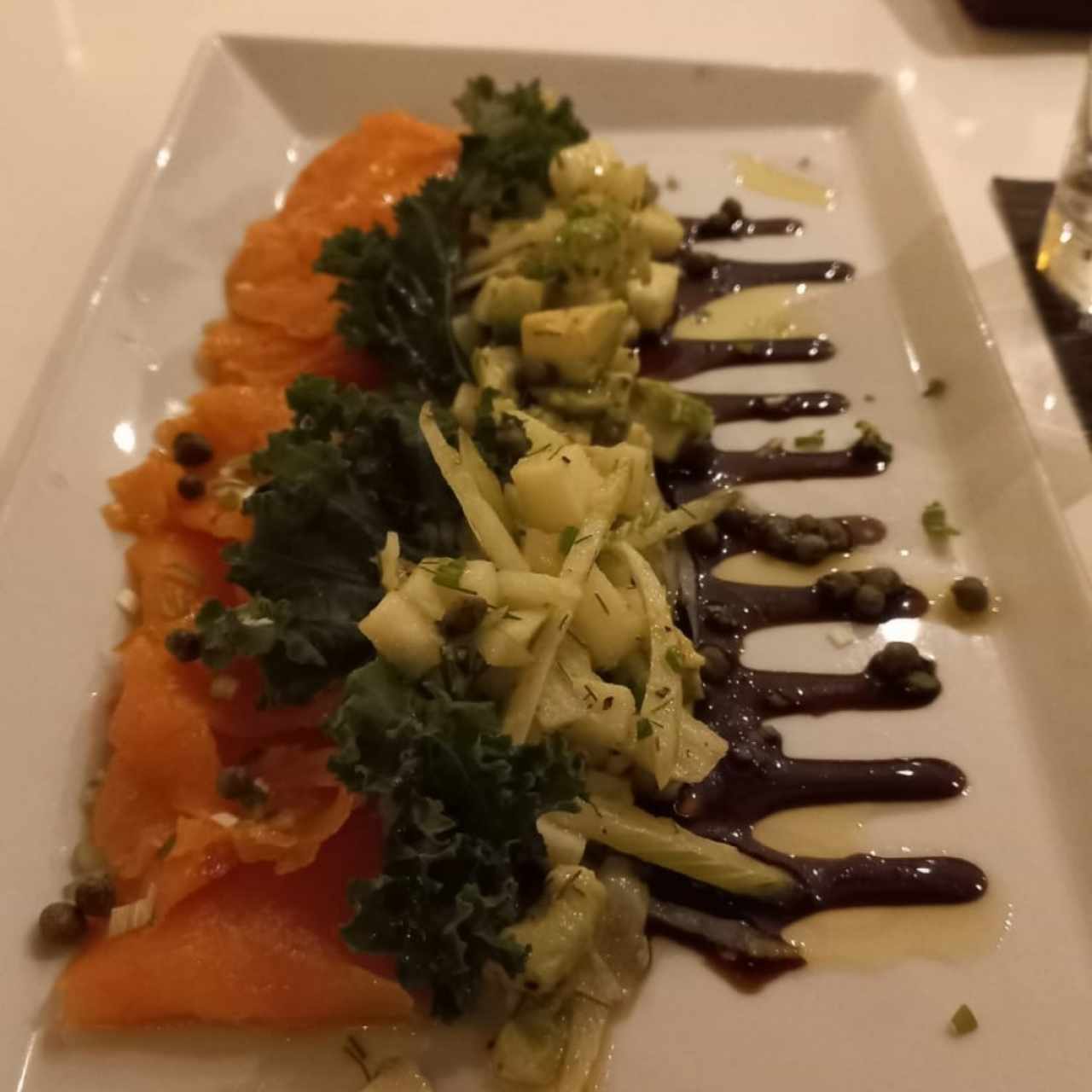 Carpaccio de salmón ahumado con aguacate, limón, aceite de oliva y arúgula