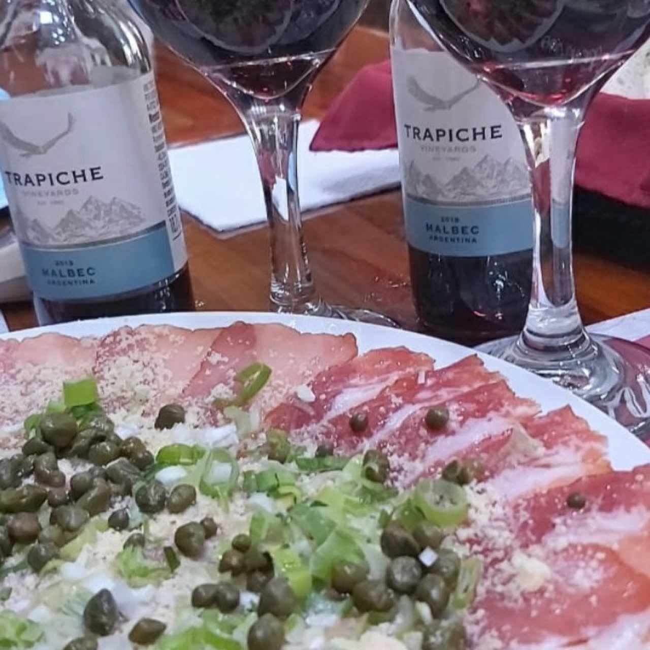 carpacho de salmón acompañado de vino tinto