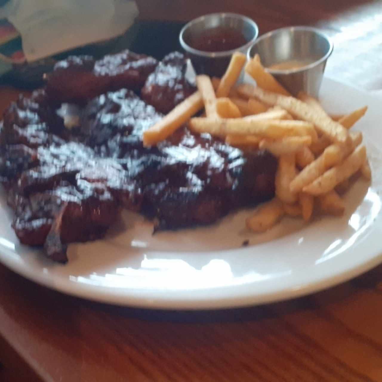costilla con alitas picantes acompañado de papas fritas
