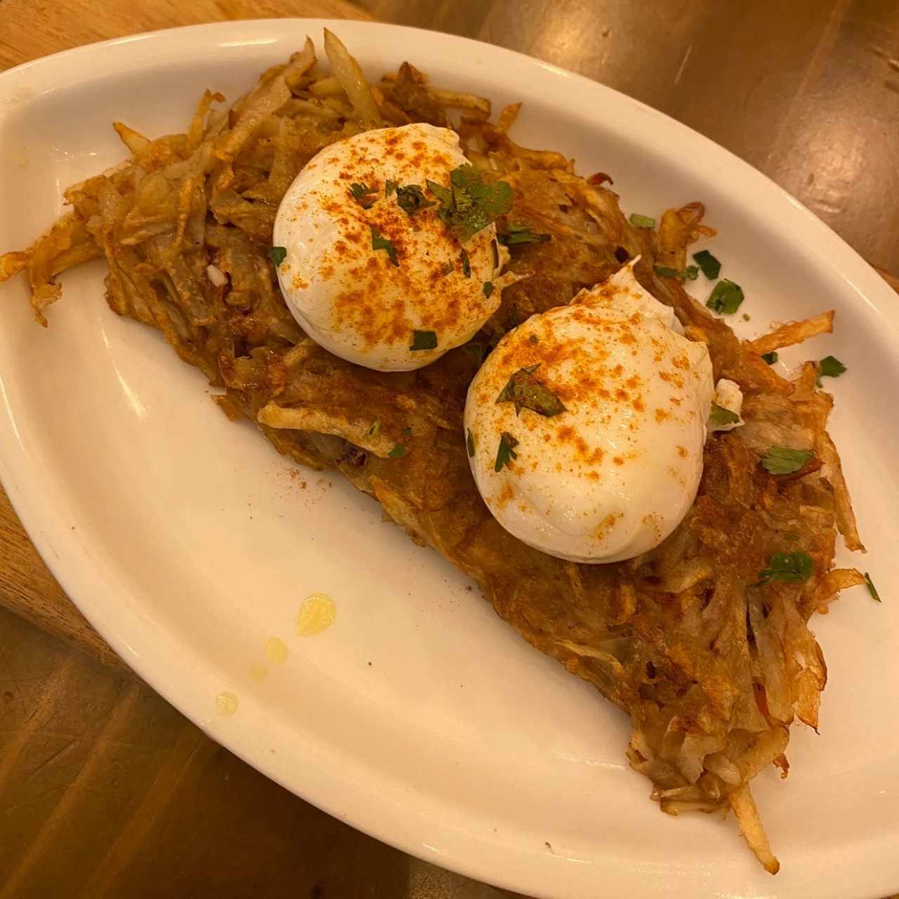 Huevos poché sobre cama Hashbrown