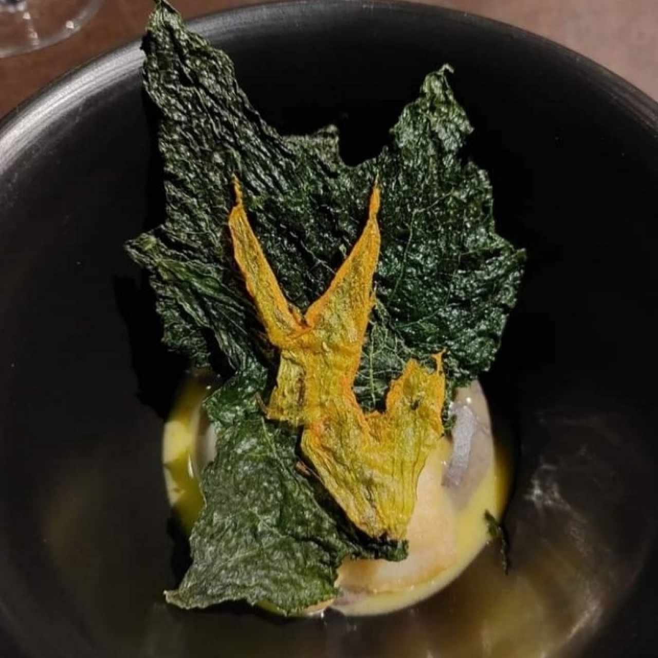 Róbalo con hojas de güisquil, flor de calabaza y salsa de frijol. 
