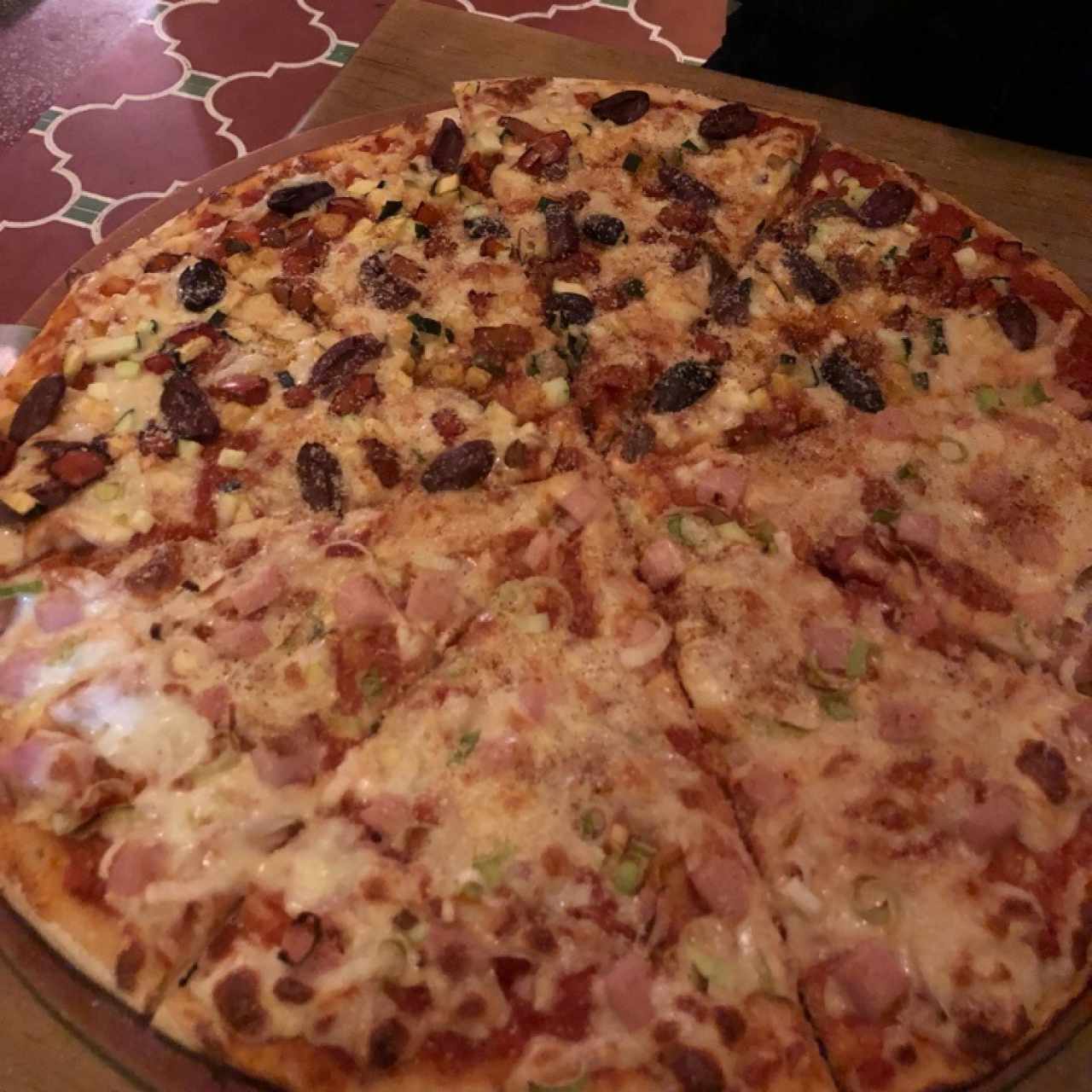 pizza con jamon de lomo y cebollin, zuchini con pimientos rojos y alcaparra