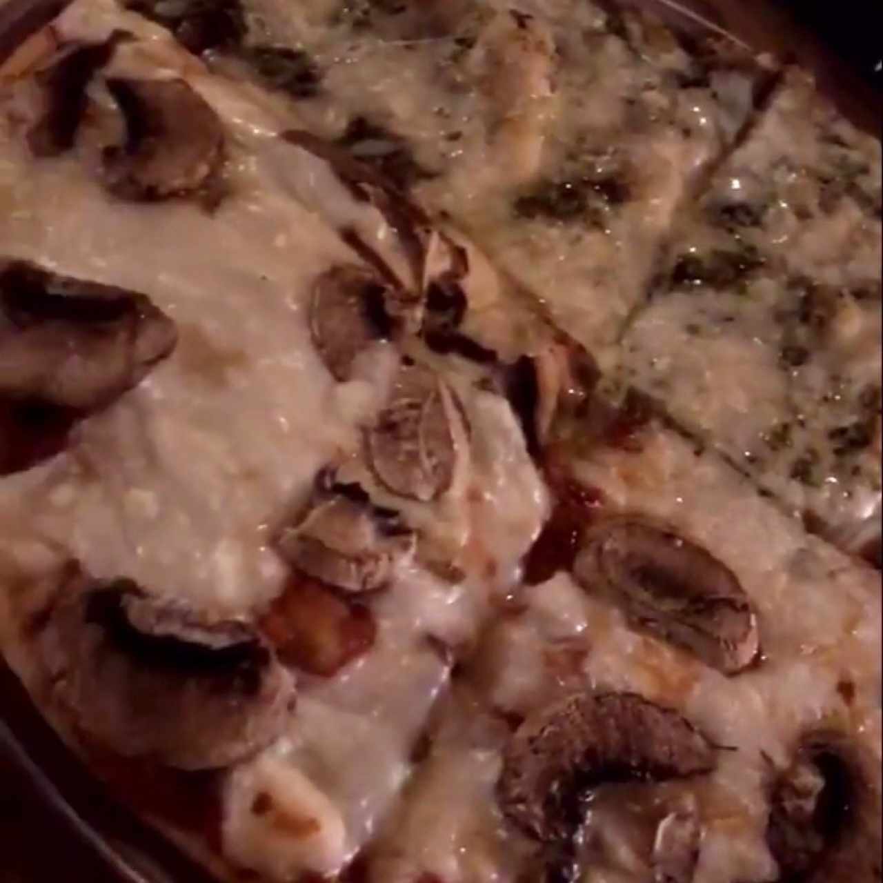 Pizza personal mitad hongos y mitad pesto.