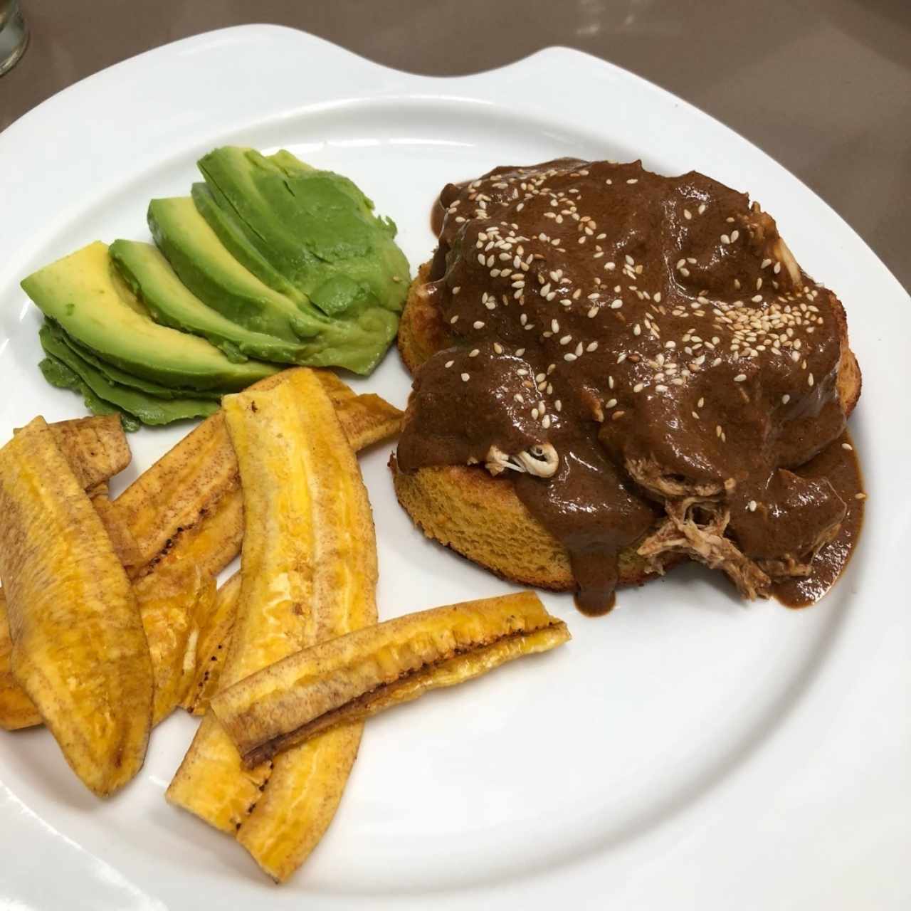 pollo en salsa mole sobre pastel de maíz 