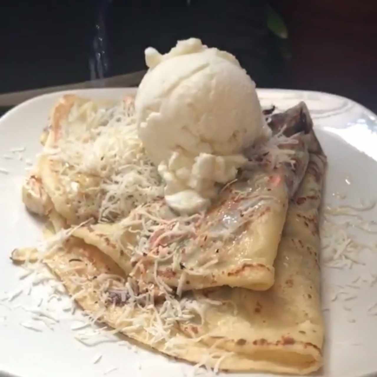 Crepa flameada de ron, coco rayado, nutella y helado