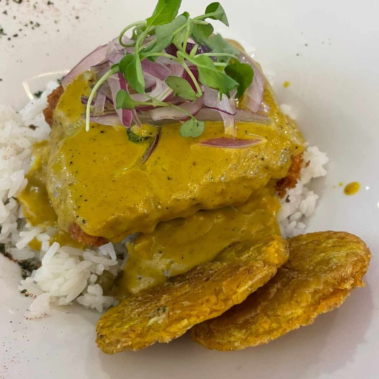 Corvina al curry con patacones y arroz con guandú