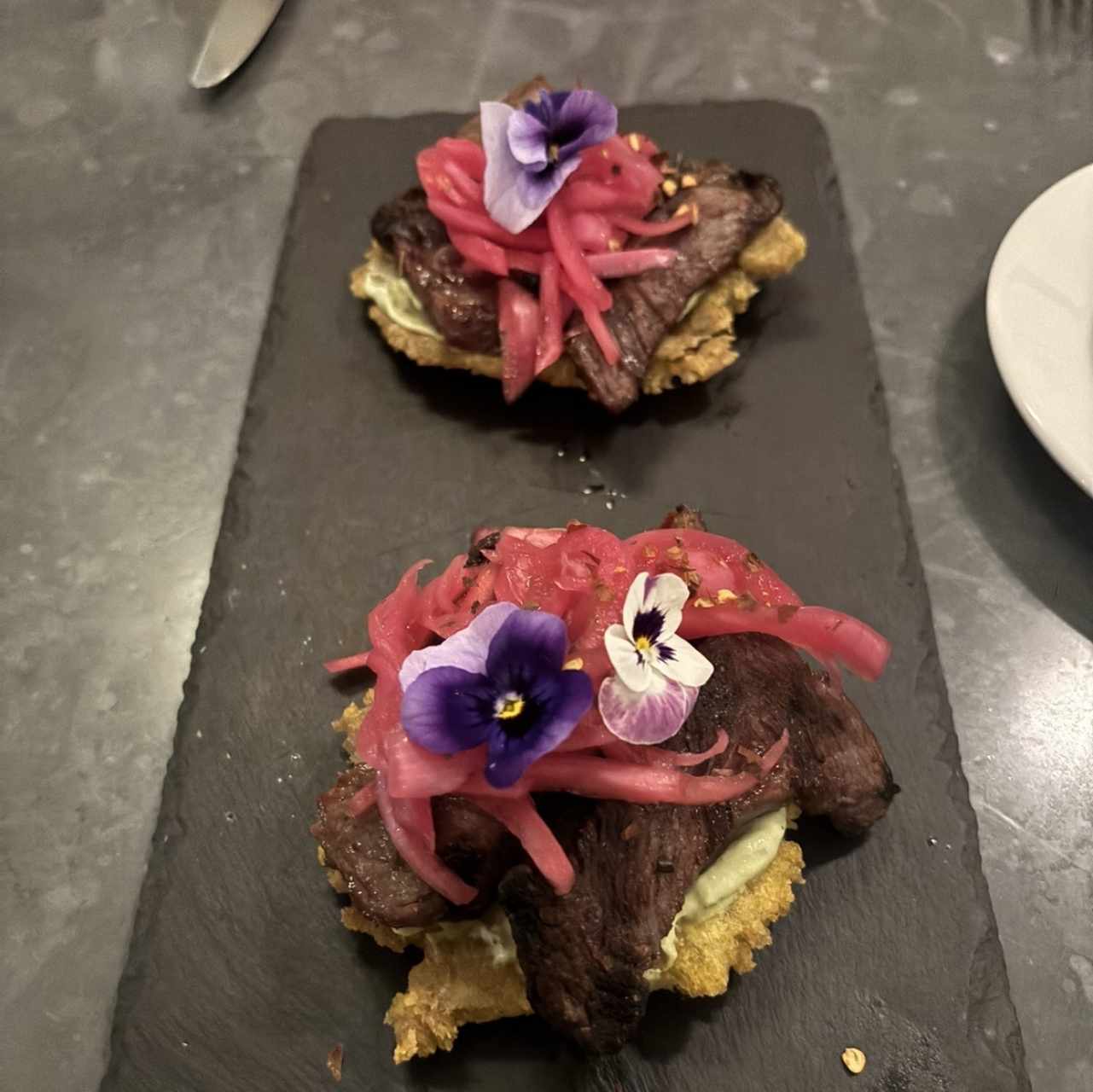 Entrada de carnitas sobre patacones