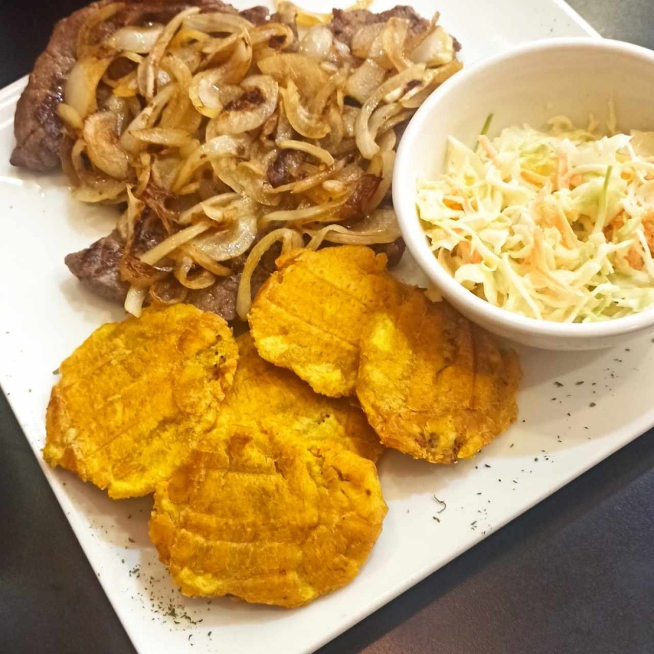 Bistec encebollado con plátanos y ensalada