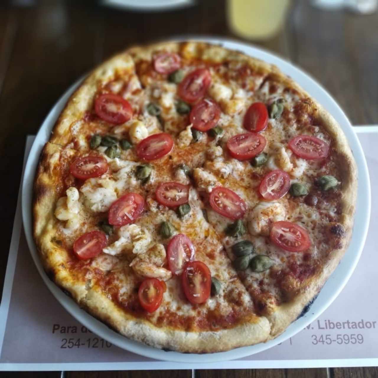Pizza de camarones, anchoas y tomate