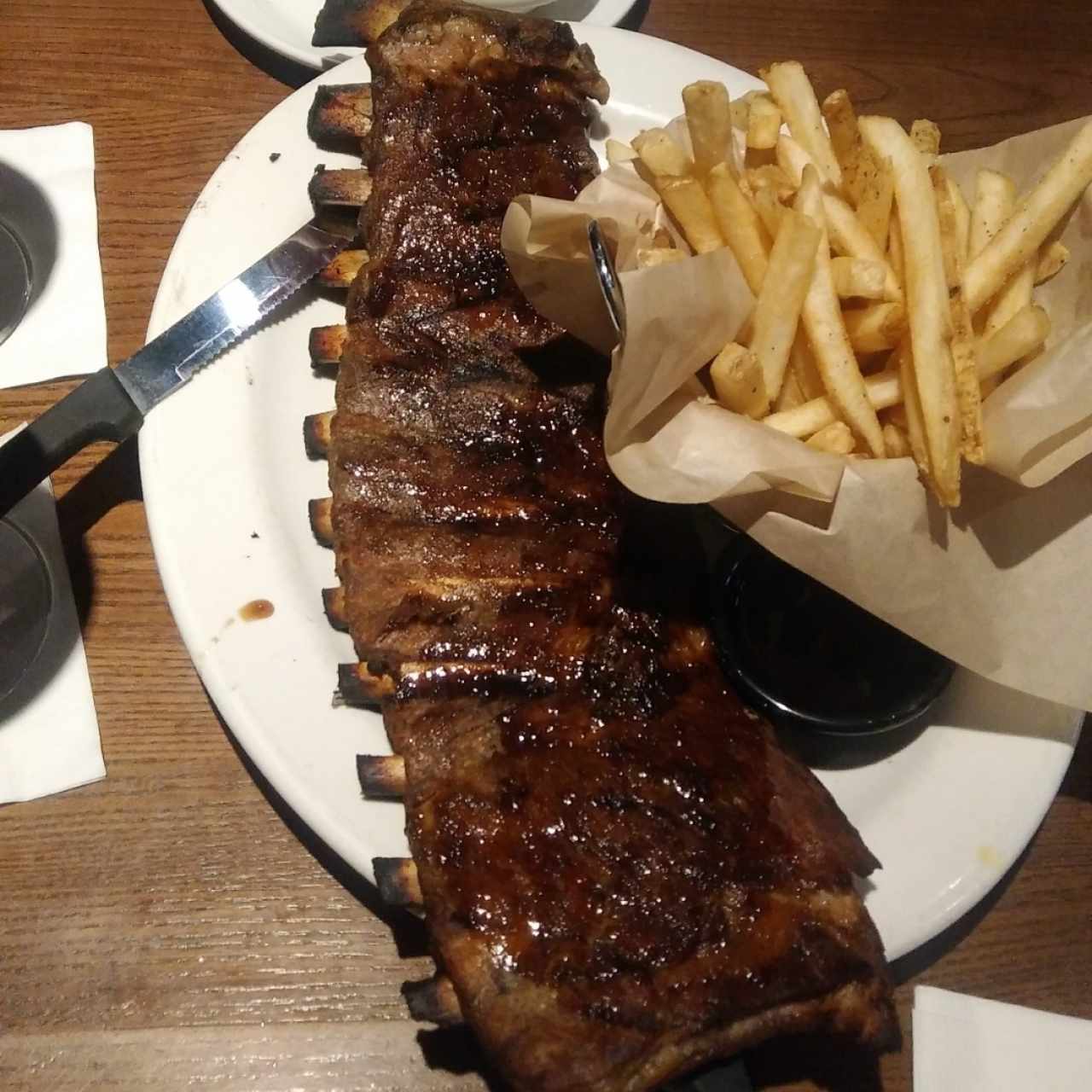 Jack Daniel's Glazed Ribs (porción completa) con papas fritas, ensalada col y salsa Jack Daniel's adicional.