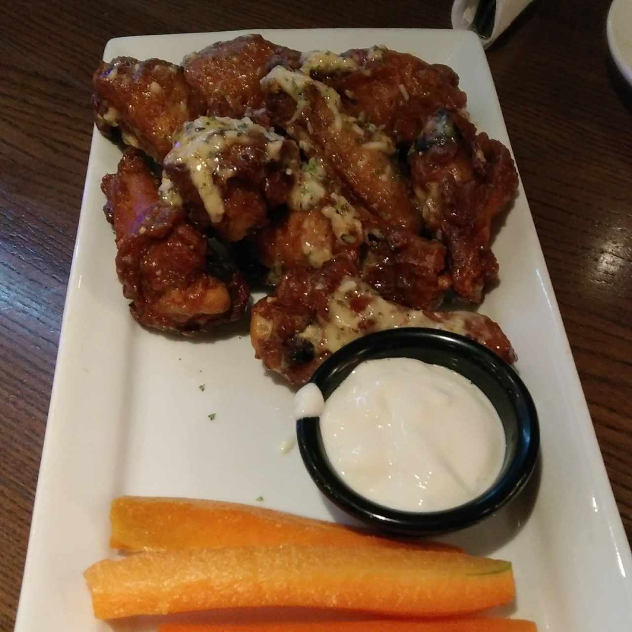 Alitas bañadas en salsa "Spicy Garlic and Parmesan Cheese".