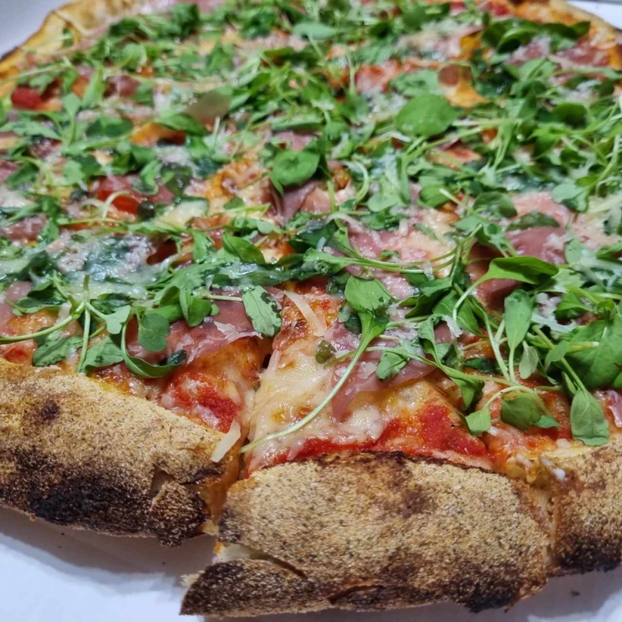 Katané Salsa de tomate, mozzarella, jamón serrano (prosciutto crudo), tomate cherry, queso crema Philadelphia, arúgula, parmesano.