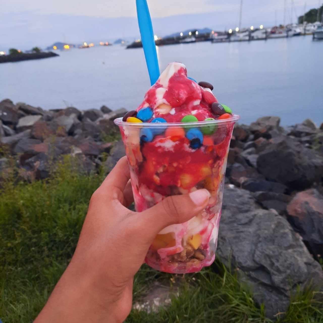 parfait con mango, piña, frambuesa y salsa de frambuesa. cereales de almendra, mani y coco