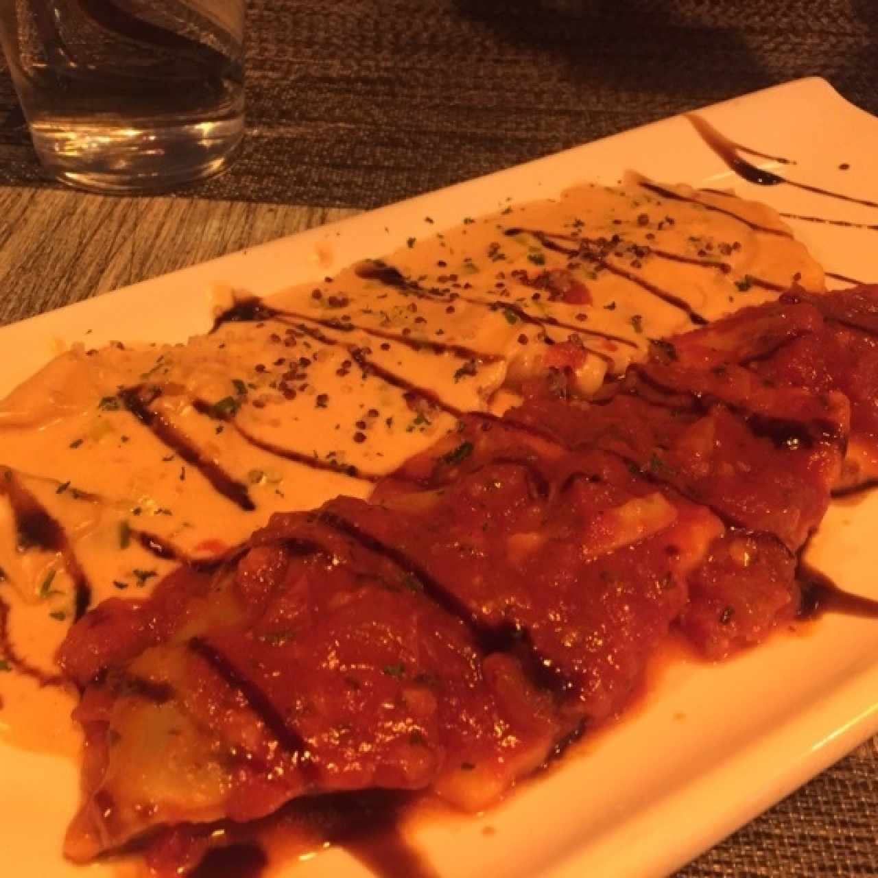 Duo de Ravioli de Salmon Ahumado y Queso Ricotta, a la Crema de Cebollina Junto a Raviolis de Berenjena a la Pizzaiola.
