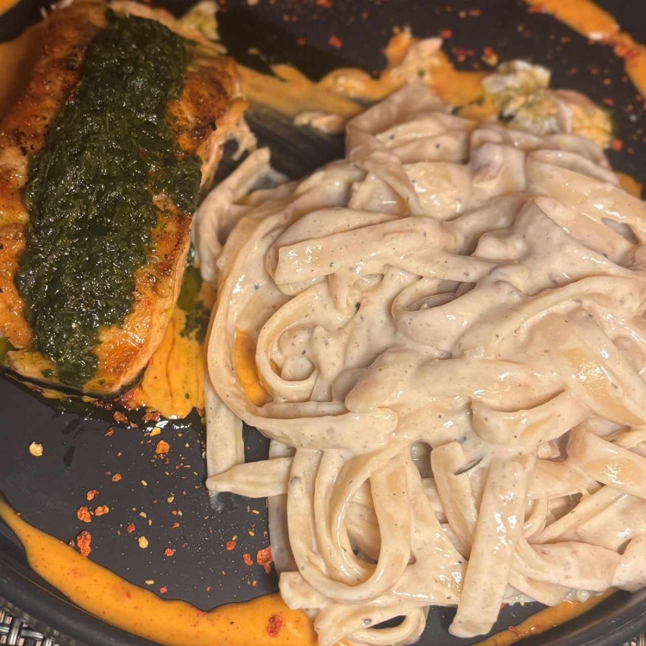 Salmon con cilantro y fetruccine Sueltos fetuccini, salteados en una salsa a base de crema de leche fresca, funghi porcini, cebolla, prosciutto crudo, salsa de trufas, grana padano y especies italianas, al final, esta delicia es paseada por una ruota de grana padano, para impregnar del queso que ha sido curado por al menos 18 meses de un sabor único e inigualable