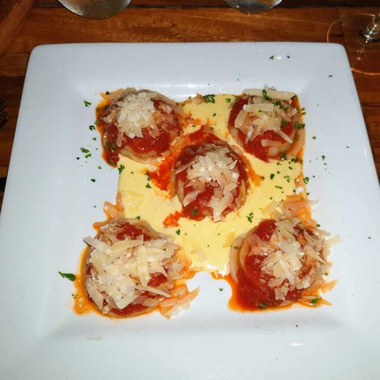 Sorrentinos de jamón y mozzarella con salsa pomodoro y esacamas de parmesano