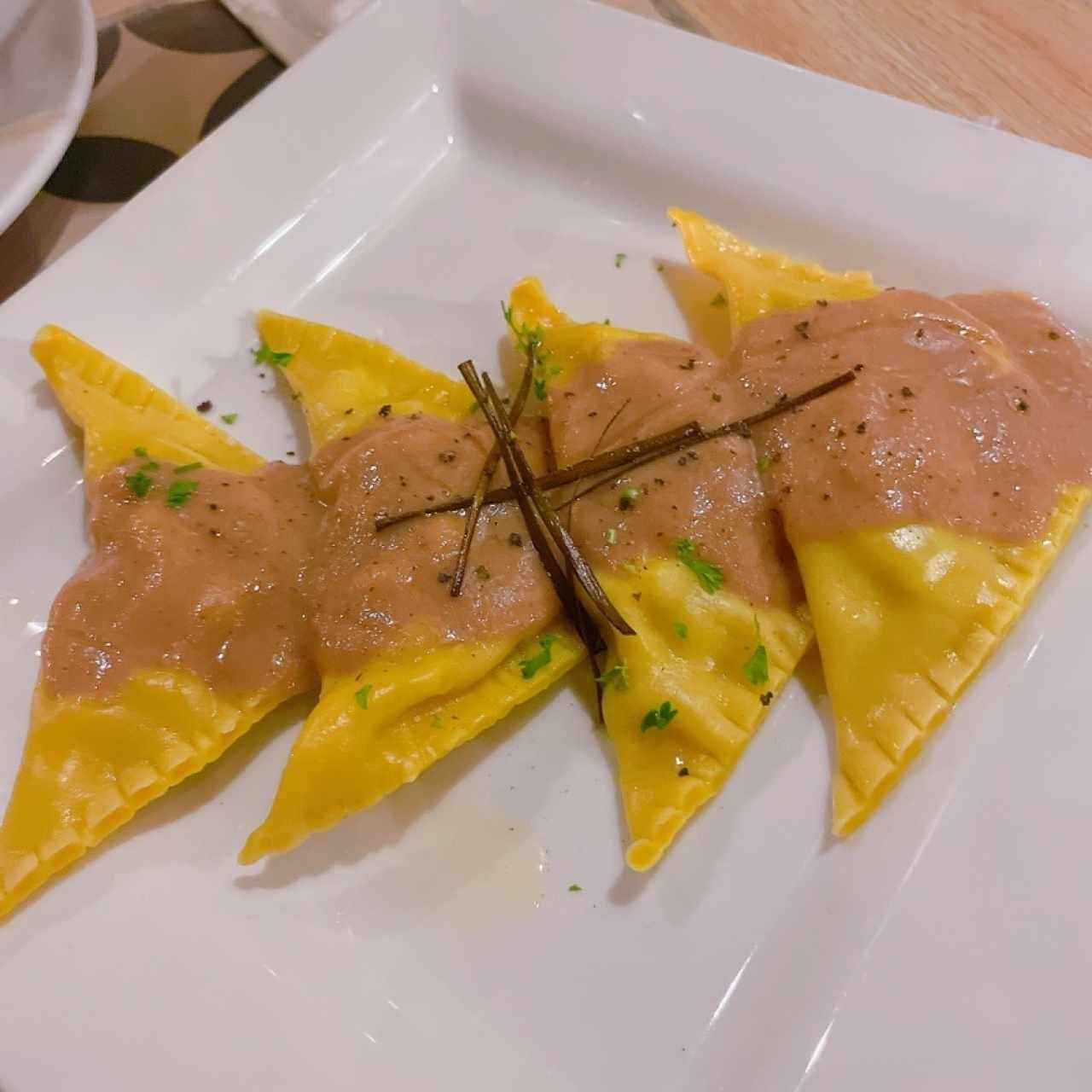 Raviolis de pasta wonton rellenos de camarón y corvina con salsa de hongos y aceite de trufa
