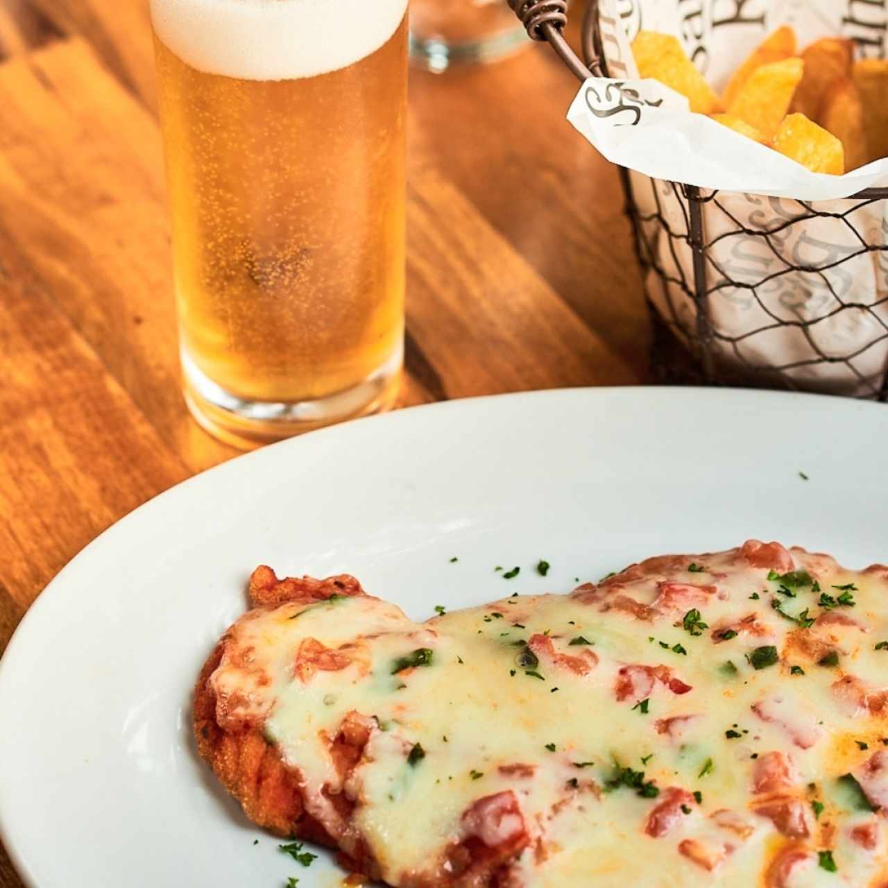 Milanesa de pollo a la napolitana con patatas fritas