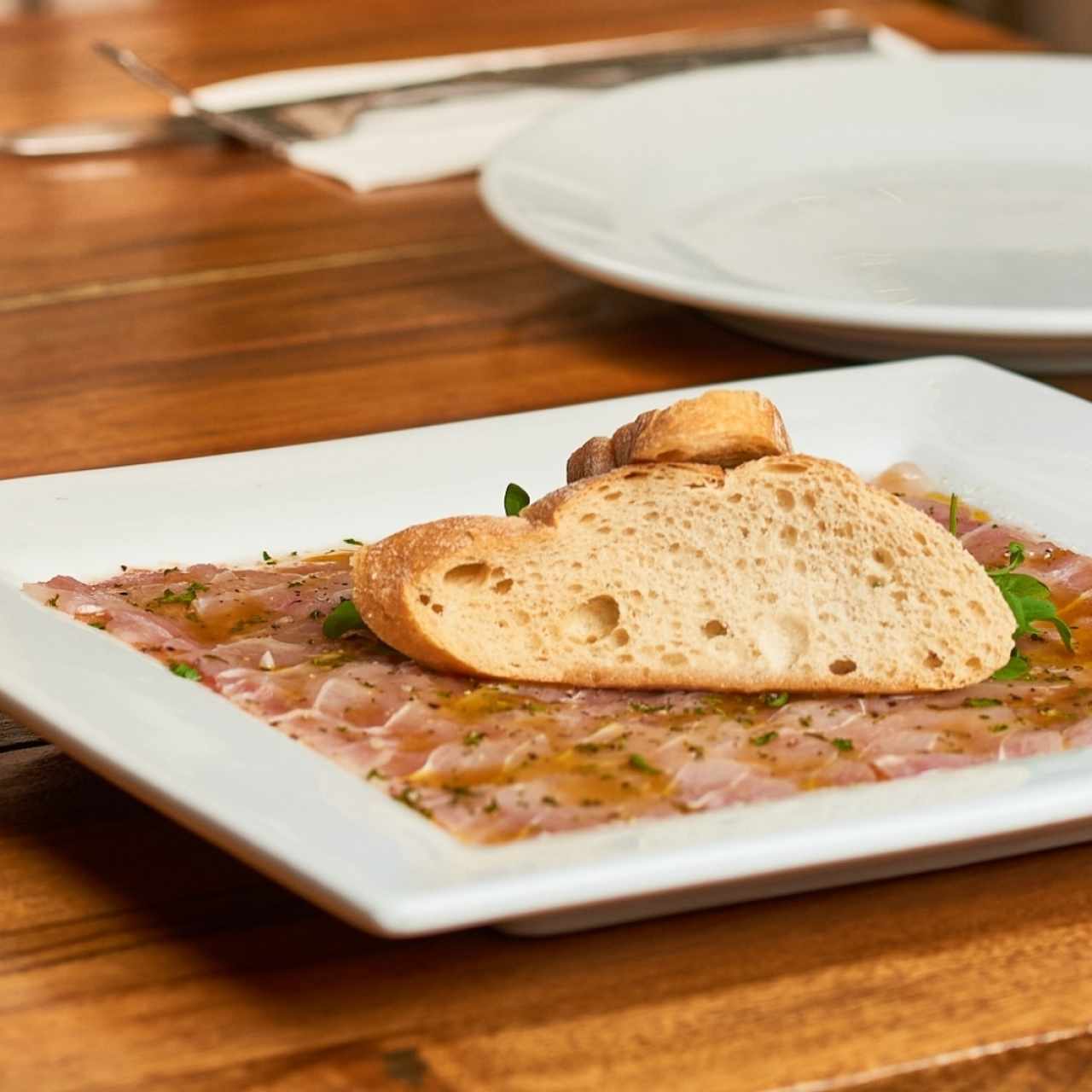 Carpaccio de corvina en base de tomate fresco rallado y aceite de oliva 100%