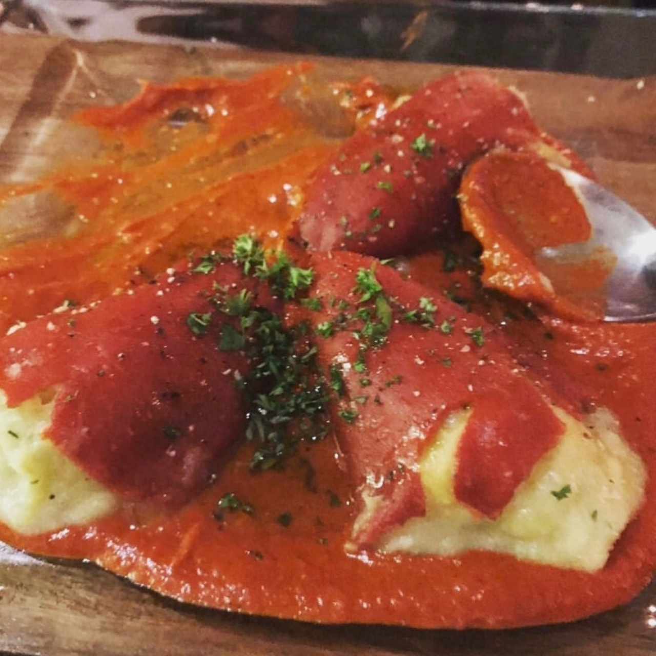 Raviolis de pasta wonton rellenos de camarón y corvina con salsa de hongos y aceite de trufa