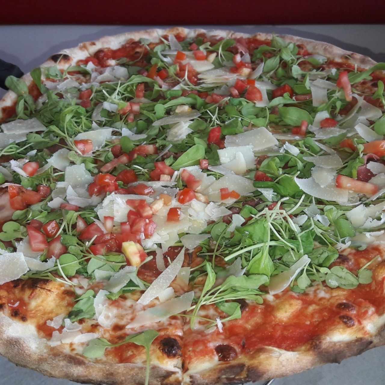 pizza con jamón serrano, tomate y rúgula
