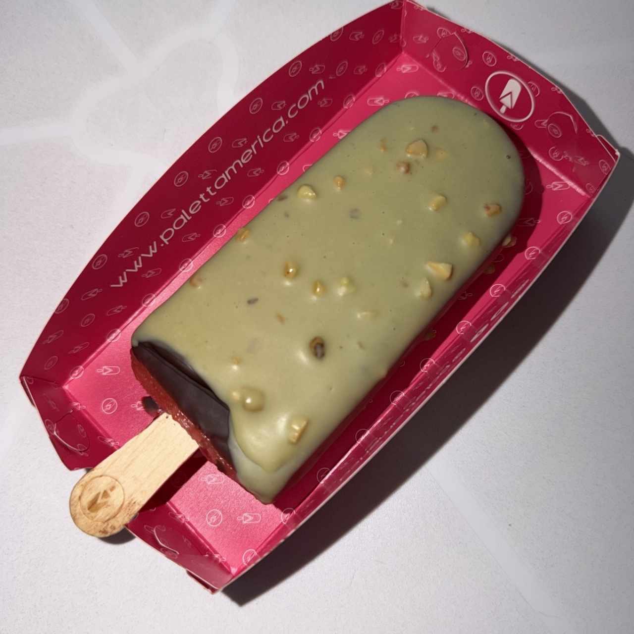 Paleta de fresa rellena de leche condensada, chocolate negro y pistacho