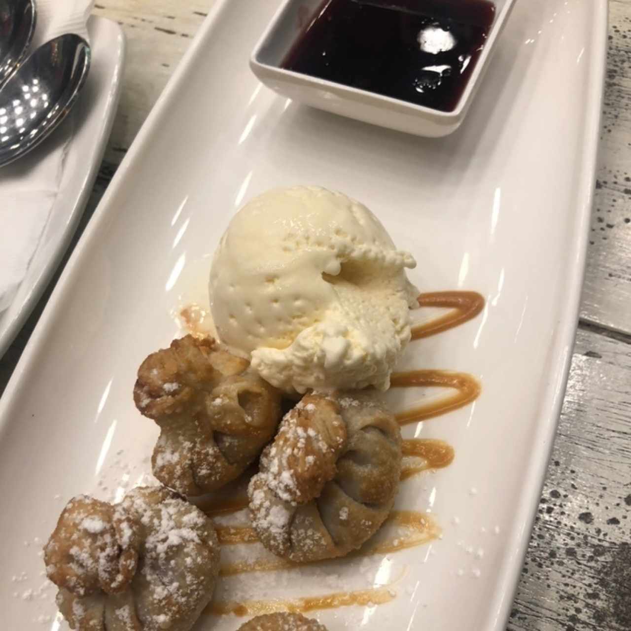 bao con dulce de leche, helado y una salsa de frutos rojos