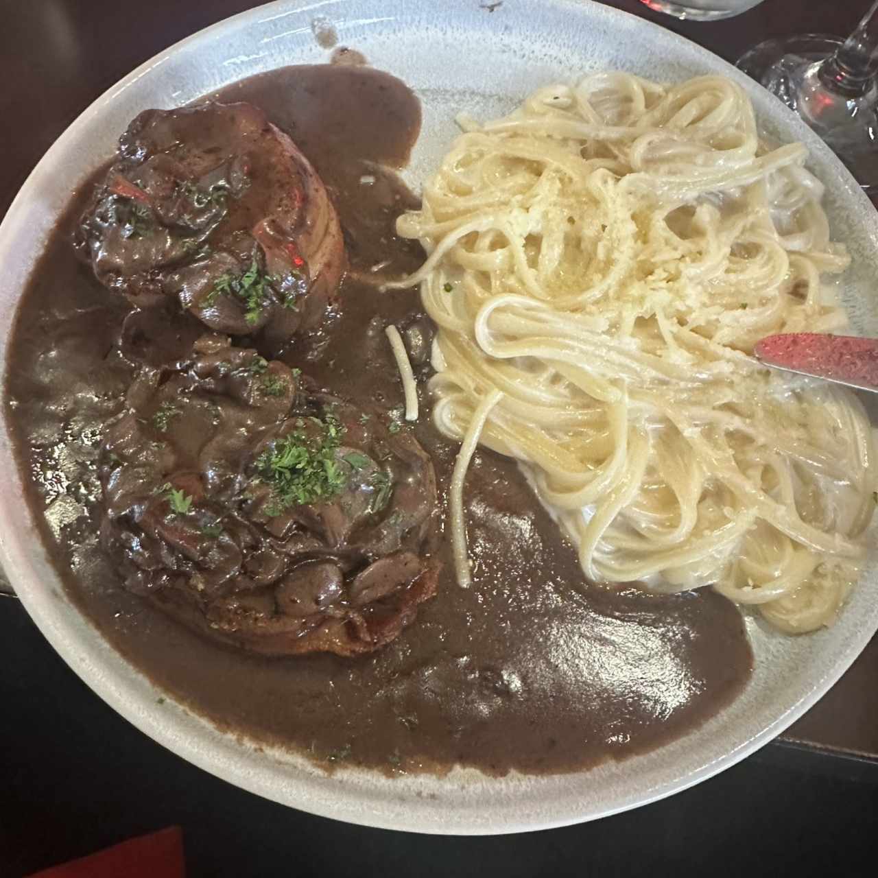 Filete de res envuelto en bacon en salsa de vino tinto con hongos