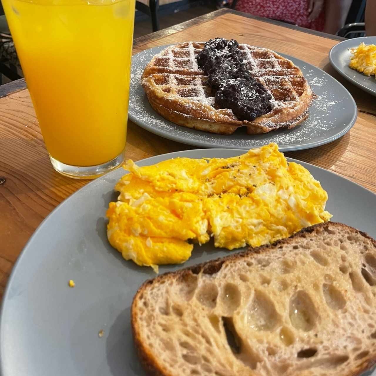 Huevos revueltos con tostada, wafles con frutos rojos y jugo de maracuyá