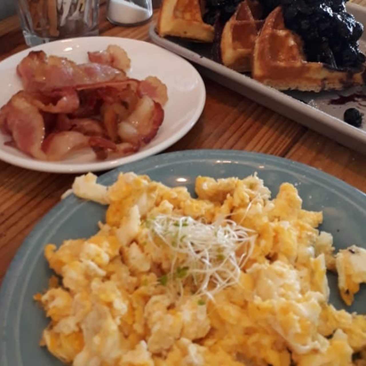 huevos revueltos, bacon y waffles de blueberry